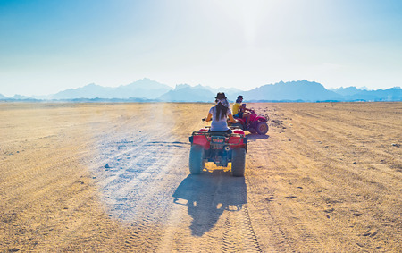 The tourists ride on quads through the Sahara desert to the Bedouin village, Egypt.の写真素材