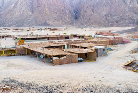The tiny shacks with the roofs and walls made of dry vegetation in Bedouin village, Sahara, Egypt.