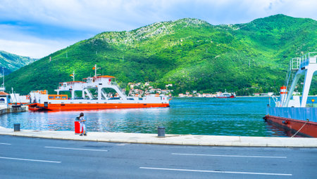 The bright ferries in Verige Strait with the green mountains on the background, Montenegro.のeditorial素材