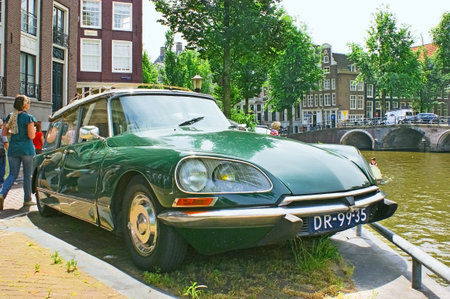 Amsterdam - July 01, 2010: Retro car Citroen DS parked on the embankment of the canal, on July 01 in Amsterdam.のeditorial素材