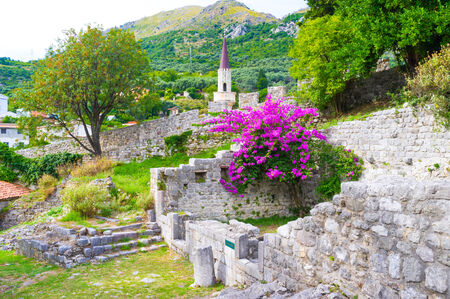 The old fortress walls around Stari Bar covered with lush gardens, beautiful green trees and colorful flowers, Montenegro.の写真素材