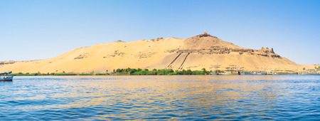 Panorama of the western bank of Nile river with the famous ancient landmark, Aswan, Egypt.