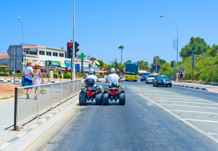 AYIA NAPA, CYPRUS - AUGUST 1, 2014: Two friends talk during the lazy riding on quads, on August 1 in Ayia Napa.のeditorial素材