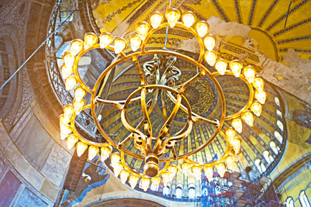 ISTANBUL, TURKEY - JANUARY 13, 2015: The  golden chandelier with the central dome of Hagia Sophia on the background, on January 13 in Istanbul.のeditorial素材