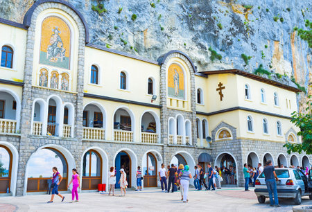 NIKSIC, MONTENEGRO - JULY 17, 2014: The lower church of the Holy Trinity of Ostrog monastery with the numerous tourists and pilgrims next to the entrance, on July 17 in Niksic.のeditorial素材