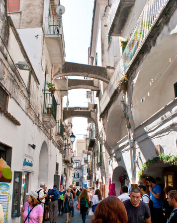 AMALFI, ITALY - OCTOBER 5, 2012: The tourists walk along the narrow medieval street with numerous cafes and stalls, on October 5 in Amalfi.のeditorial素材