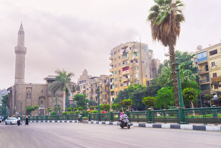 CAIRO, EGYPT - OCTOBER 9, 2014: The street of Port Said with the medieval mosque and the lush garden along the residential houses, on October 9 in Cairo.のeditorial素材