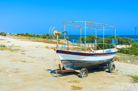 The old boat like the symbol of the fishing village welcomes tourists, coming to Zugi, Cyprus.の写真素材