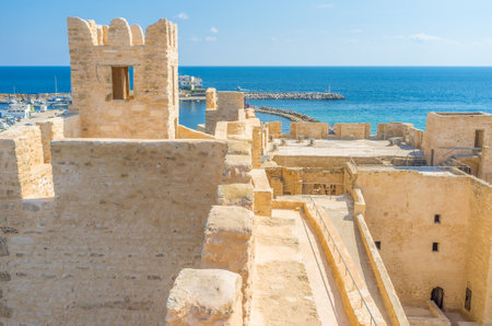The pastel walls of Ribat with bright blue sea on the background, Monastir, Tunisia.のeditorial素材