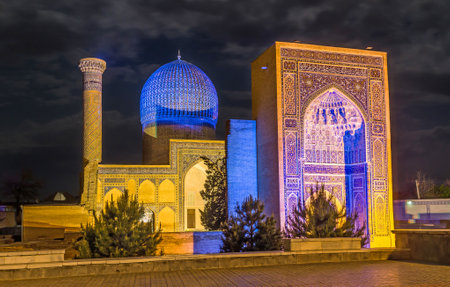 The blue and yellow lighting of Gur-e Amir mausoleum recreates its natural colors - blue dome and yellow brick walls, Samarkand, Uzbekistan.のeditorial素材