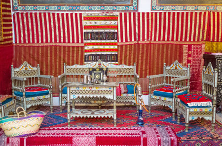 KAIROUAN, TUNISIA - AUGUST 30, 2015: The hookah room in the Mansion of Governor with carved wooden furniture and walls decorated with rugs, on August 30 in Kairouan.のeditorial素材