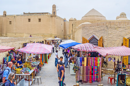 KHIVA, UZBEKISTAN, MAY 3, 2015: The tourists and locals enjoy the traditional asian bazaar in the narrow street next to Allakuli Khan Caravan Saray, on May 3 in Khiva.のeditorial素材