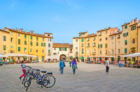LUCCA, ITALY - APRIL 30, 2013: The Piazza del'Anfiteatro is the round square, surrounded by the medieval houses, with lovely cafes and taverns, souvenir stalls and tiny shops, on April 30 in Lucca.のeditorial素材