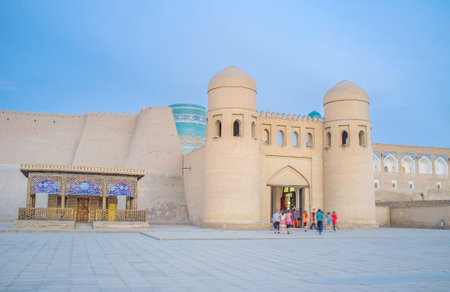 KHIVA, UZBEKISTAN - MAY 3, 2015: The West Gates to Itchan Kala with two brick towers and Kalta Minor Minaret behind the ramparts, on May 3 in Khiva.のeditorial素材