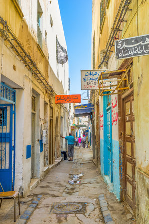 SFAX, TUNISIA - SEPTEMBER 3, 2015: The old colorful signboards of the stores and workshops decorate the narrow street of Medina, on September 3 in Sfax.のeditorial素材