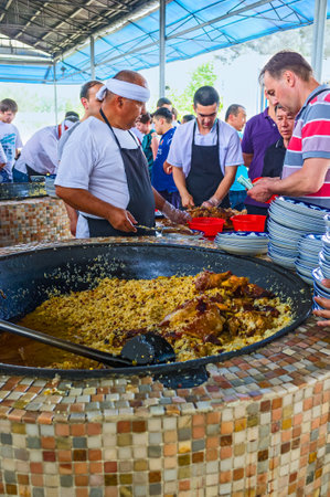 TASHKENT, UZBEKISTAN - MAY 7, 2015: People enjoy the process of pilaf cooking and buy, when it's ready, on May 7 in Tashkent.のeditorial素材