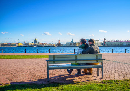 SAINT PETERSBURG- -APRIL 24, 2015: Couple sit on the bench and enjoy the great view on the city architecture, on April 24 in Saint Petersburg.のeditorial素材