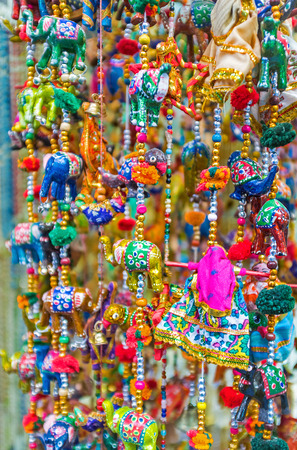 The colorful wind chimes with toy elephants, dolls and different beads in market stall, Jerusalem, Israel.の写真素材