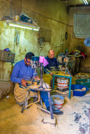 BETHLEHEM, PALESTINE - FEBRUARY 18, 2016: The carpenters working with the slotting machine, drilling wooden souvenirs, on February 18 in Bethlehem.のeditorial素材