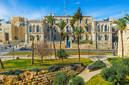 The building of the St Louis French Hospital behind the palms of the National Garden, Jerusalem, Israel.のeditorial素材