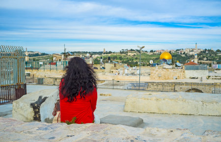 The lonely girl sits on the roof of Jerusalem's house  and watches the views, thinking about eternity, Israel.のeditorial素材