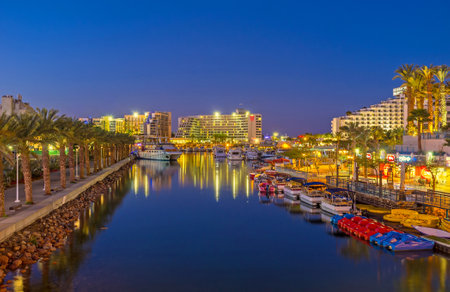 EILAT, ISRAEL - FEBRUARY 24, 2016: The romantic evening promenade along marina with moored boats and yachts, on February 24 in Eilat.のeditorial素材