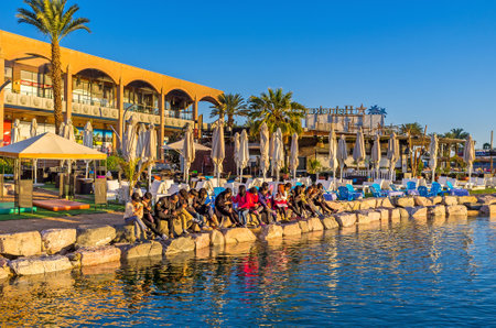 EILAT, ISRAEL - FEBRUARY 24, 2016: The group of religious tourists come to the North beach to read the Bible and pray at the time of sunrise, on February 24 in Eilat.のeditorial素材