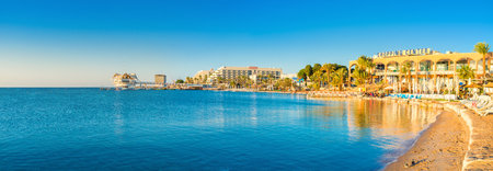 The cozy beach with outdoor cafes and bars and the modern dive station on the background, Eilat,...