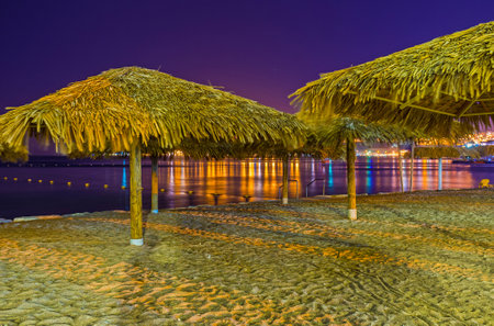 The night beach is the best place for the romantic walks, enjoying the scenic reflection of city lights in water, Eilat, Israel.のeditorial素材