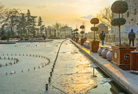 ANKARA, TURKEY - JANUARY 16, 2015: The winter sunset over the Haci Bayram Square with the frozen pond, reflecting the sun beams, on January 16 in Ankara.のeditorial素材