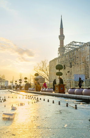 ANKARA, TURKEY - JANUARY 16, 2015: The frozen pond with the bright sun path on ice and the huge wall of the ancient Augustus Temple on the background, on January 16 in Ankara.のeditorial素材