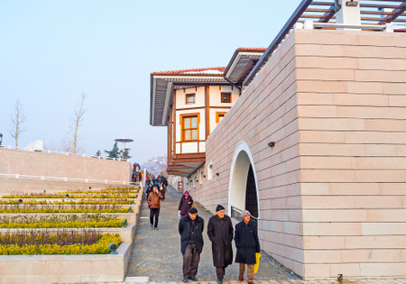 ANKARA, TURKEY - JANUARY 16, 2015: The tourists and locals leave the Haci Bayram Mosque, walking along the modern street with green flower beds, on January 16 in Ankara.のeditorial素材