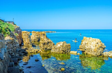 The picturesque coastline with the ruins of the ancient Roman city in water, Caesaria, Israel.