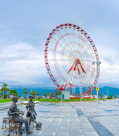 BATUMI, GEORGIA - MAY 24, 2016: The sculpture group Me, You and Batumi, with the ferris wheel on the background in the Miracle Park, on May 24 in Batumi.のeditorial素材