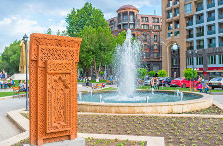YEREVAN, ARMENIA - MAY 29, 2016: The bright orange Khachkar with the complex carved pattern in the...