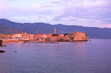 The medieval fortress of Budva looks amazing in twilight hours, the stone buildings surrounded by purple waters of the sea, Montenegro.のeditorial素材