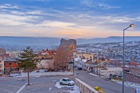 The winter evening in the small mountain resort of Ortahisar with the snowbound Erciyes Mount on the background, Cappadocia, Turkey.のeditorial素材
