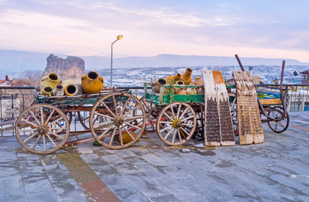 The wintage wooden wagons with clay pots decorate the street of Ortahisar mountain resort, Cappadocia, Turkey.のeditorial素材