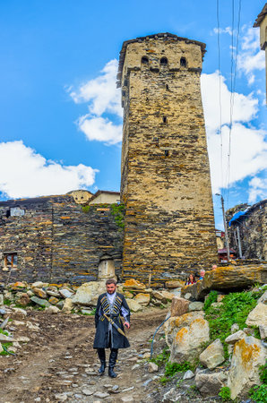 USHGULI, GEORGIA - MAY 22, 2016: The  young Svan in traditional costume goes down the narrow medieval street, on May 22 in Ushguli.のeditorial素材