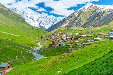 The amazing view of Zhibiani village next to the winding Enguri river and snowy Shkhara Mount on the background, Ushguli, Georgia.の写真素材