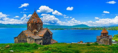 Panoramic view of Sevan Peninsula with both Churches of Sevanavank Monastery - Holy Apostles and Holy Mother of God, on the green meadow and with the pure Sevan Lake on the background, Armenia.の写真素材