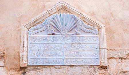 RETHYMNO, GREECE - OCTOBER 16, 2013: The old arabic inscription, carved on the marble block, is built in the house's wall, on October 16 in Rethymno.のeditorial素材