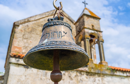 The close-up view of the small bell at the frontage of old church in Saro village, Georgia.の写真素材