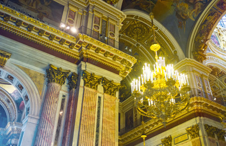 SAINT PETERSBURG, RUSSIA - APRIL 25, 2015: The massive chandelier and richly decorated walls of St Isaac's Cathedral with stone, painted, carved and gilt elements, on April 25 in Saint Petersburg.のeditorial素材