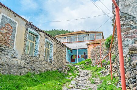 The old stone residential house on the mountain slope with the narrow stone path, Stepantsminda, Georgia.の写真素材