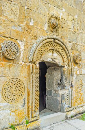 The entrance to Tsminda Sameba (Holy Trinity) Church decorated with the medieval rosette carved patterns, Gergeti, Georgia.の写真素材