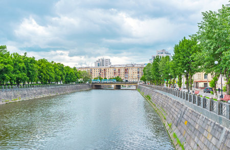 KHARKOV, UKRAINE - MAY 20, 2016: The green trees on the banks of Lopan River make them the best place for walks and relax in shade, on May 20 in Kharkov.のeditorial素材
