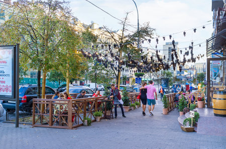 KIEV, UKRAINE - SEPTEMBER 18, 2016: The outdoor terrace of the Georgian restaurant decorated with the bunches of grapes, drying over the street, on September 18 in Kiev.のeditorial素材