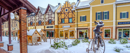 KIEV, UKRAINE - NOVEMBER 11, 2016: The Dutch style street with the bronze statue of a man, riding the vintage bicycle, surrounded by white fluffy snow, on November 11 in Kiev.のeditorial素材