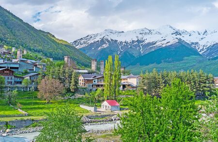 The sunny Mestiacchala river valley overlooks shady slopes of Banguriani mountain range, Mestia, Upper Svaneti, Georgia.の写真素材